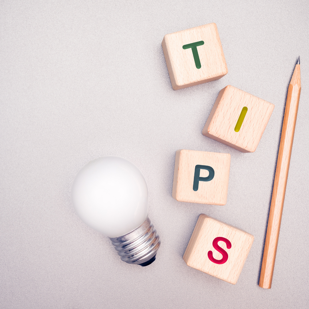 photo of a light bulb, wood cubes that make the word TIPS and a pen