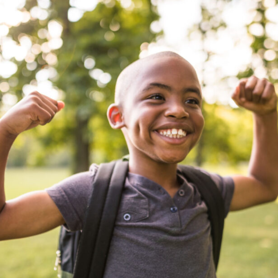 photo of a kid smiling and flexing their muscles